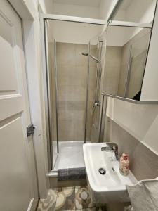 La salle de bains blanche est pourvue d'une douche et d'un lavabo. dans l'établissement Residence am Rathausplatz 3, à Sarrebruck