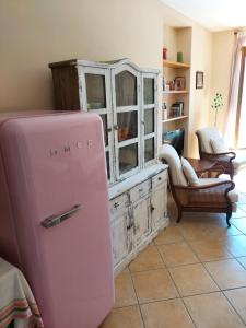 a pink refrigerator in a room with a cabinet at Casa Angela Gravedona Consiglio di Rumo in Consiglio di Rumo
