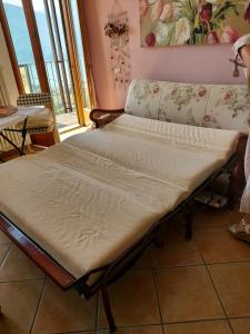 Bett in einem Zimmer neben einem Fenster in der Unterkunft Casa Angela Gravedona Consiglio di Rumo in Consiglio di Rumo