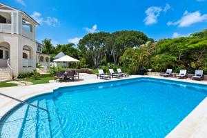 una piscina con sillas y una casa en Luxury 5 BR Villa in Sandy Lane en Saint James