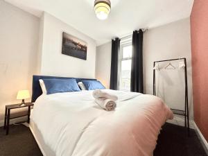 a bedroom with a bed with white sheets and a window at Contractor HQ Spacious & Central 4 Bed Home in Newcastle upon Tyne