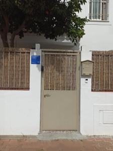 a white building with a door and a fence at Nao Victoria in Gelves