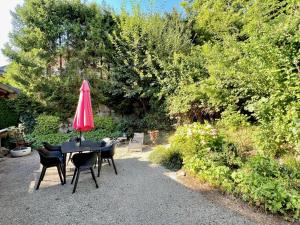 a table and chairs with a pink umbrella on top at CHALET BELLE KITZ by Belle Stay in Kitzbühel