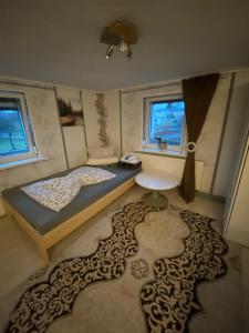 een slaapkamer met 2 bedden en een groot tapijt bij "Ruhige Naturlage im Wald" Ferienhaus mit Sauna in Großnaundorf