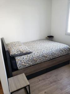 1 cama en un dormitorio con suelo de madera en Charmant studio à 2 pas du tram en Nantes