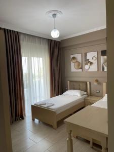 a hotel room with two beds and a window at Durmishi Rooms & Apartments & Beach in Sarandë