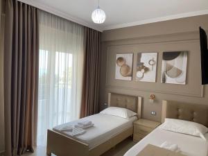 a hotel room with two beds and a window at Durmishi Rooms & Apartments & Beach in Sarandë