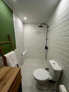 bagno con servizi igienici bianchi e parete verde di The Nook a Maleme
