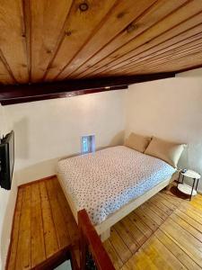 Posto letto in camera con soffitto in legno. di The Nook a Maleme