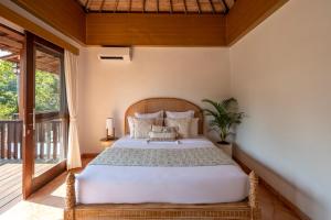 Postel nebo postele na pokoji v ubytování The Kayuan Lumbur Resort Ubud