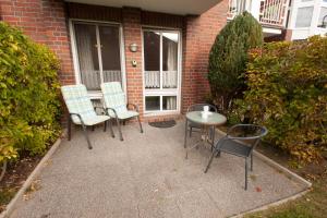 a patio with three chairs and a table and a building at 50060... in Harlesiel