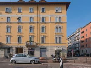 a yellow building with a car parked in front of it at [IHost Apartment] - Stendhal 49 in Milan