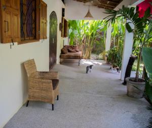 una sala de estar con 2 sillas y un gato caminando por ahí en Maison Jardin Botanique en Cap Skirring