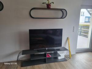 um centro de entretenimento preto com uma televisão de ecrã plano numa sala de estar em Wohnung Adam em Kelkheim
