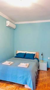 een blauwe slaapkamer met een bed met blauwe muren bij Endless view in Thessaloniki