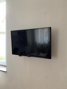 einen Flachbild-TV, der an einer Wand hängt in der Unterkunft Casetta fra ely in Meda