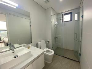 a bathroom with a toilet and a glass shower at Chiu Housestay Ha Long in Ha Long