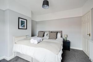a white bedroom with a bed with two pillows at Contract workers, Professionals, Families, Parking in Crewe