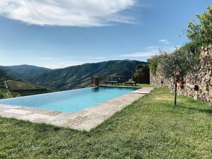 a swimming pool with mountains in the background at Quinta da Gricha in Ervedosa do Douro
