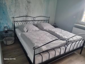 a bed with a metal frame and two pillows at Wohnung Adam in Kelkheim