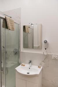 La salle de bains blanche est pourvue d'un lavabo et d'une douche. dans l'établissement Posterla22, à Bologne