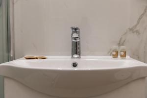 La salle de bains est pourvue d'un lavabo blanc et d'un robinet. dans l'établissement Posterla22, à Bologne