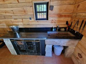 a kitchen in a log cabin with a sink at Casa do Barqueiro TREIXADURA in Castrelo de Miño +51 photos