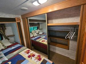 a small room with a bed and a mirror at The Mountaineer (Presque Isle Campground #4) in Presque Isle