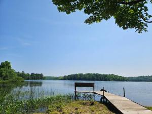 a bench sitting on a dock next to a lake at The Mountaineer (Presque Isle Campground #4) in Presque Isle