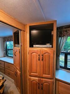a room with a entertainment center with a flat screen tv at The Mountaineer (Presque Isle Campground #4) in Presque Isle