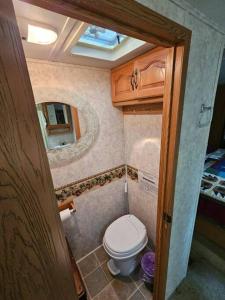 a small bathroom with a toilet and a mirror at The Mountaineer (Presque Isle Campground #4) in Presque Isle