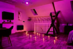 una habitación con una habitación púrpura con una persona de pie en un stand en Love Room Le Chalet / Jacuzzi / Sauna, en Château-Landon