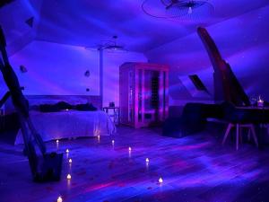 a room with a bed and candles on the floor at Love Room Le Chalet / Jacuzzi / Sauna in Château-Landon