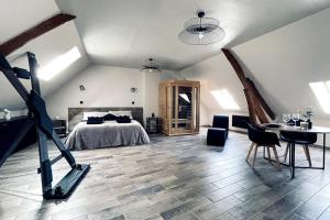 a bedroom with a bed and a table and chairs at Love Room Le Chalet / Jacuzzi / Sauna in Château-Landon