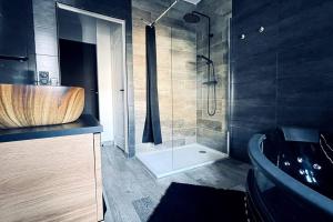 a bathroom with a wooden sink and a shower at Love Room Le Chalet / Jacuzzi / Sauna in Château-Landon