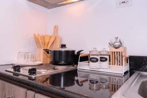 a kitchen counter with a stove with a pot on it at Condo at Greenfield in Manila
