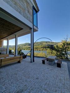 a pavilion with benches and a view of a lake at Casa do Barqueiro TREIXADURA in Castrelo de Miño