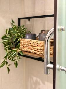 a bathroom shelf with a basket and a plant at Drive Point (Adventure Lake Resort) in Asparukhovo