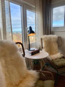 ein Wohnzimmer mit einem Tisch, einer Lampe und einem Stuhl in der Unterkunft Blas at Fronlas Café - The heart of Newport in Newport