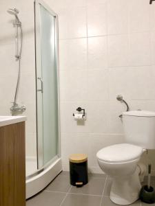 een witte badkamer met een toilet en een douche bij Drive Point (Adventure Lake Resort) in Asparukhovo