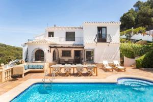 a villa with a swimming pool and a house at Casa Nunca Javea: geniet van het uitzicht in Jávea
