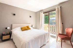 a bedroom with a bed and a window and a chair at Casa Nunca Javea: geniet van het uitzicht in Jávea +31 photos