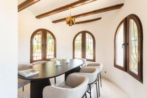 a dining room with a table and chairs at Casa Nunca Javea: geniet van het uitzicht in Jávea
