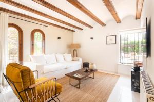 a living room with a white couch and a table at Casa Nunca Javea: geniet van het uitzicht in Jávea