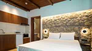 ein Schlafzimmer mit einem Bett und einer Steinmauer in der Unterkunft Πέτρινη Αγροικία 2 Stone Manor 2 in Kastraki