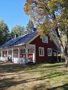 a red and white house with a tree at Sinnerskog - Urlaub im alten Bahnhof in Högsby