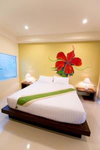 
a bedroom with a bed, a desk, and a painting on the wall at Maryo Resort - SHA Plus in Chiang Rai
