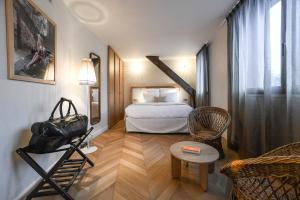 une chambre d'hôtel avec un lit et une chaise dans l'établissement Grand Hôtel Du Parc - Teritoria, à Aix-les-Bains