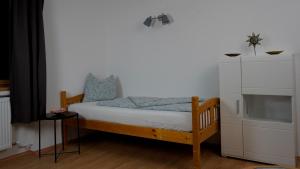 a small bedroom with a bed and a white cabinet at Apart Weitblick in Ladis