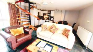 sala de estar con sofá y silla en Dolgun Uchaf Guesthouse and Cottages in Snowdonia en Dolgellau